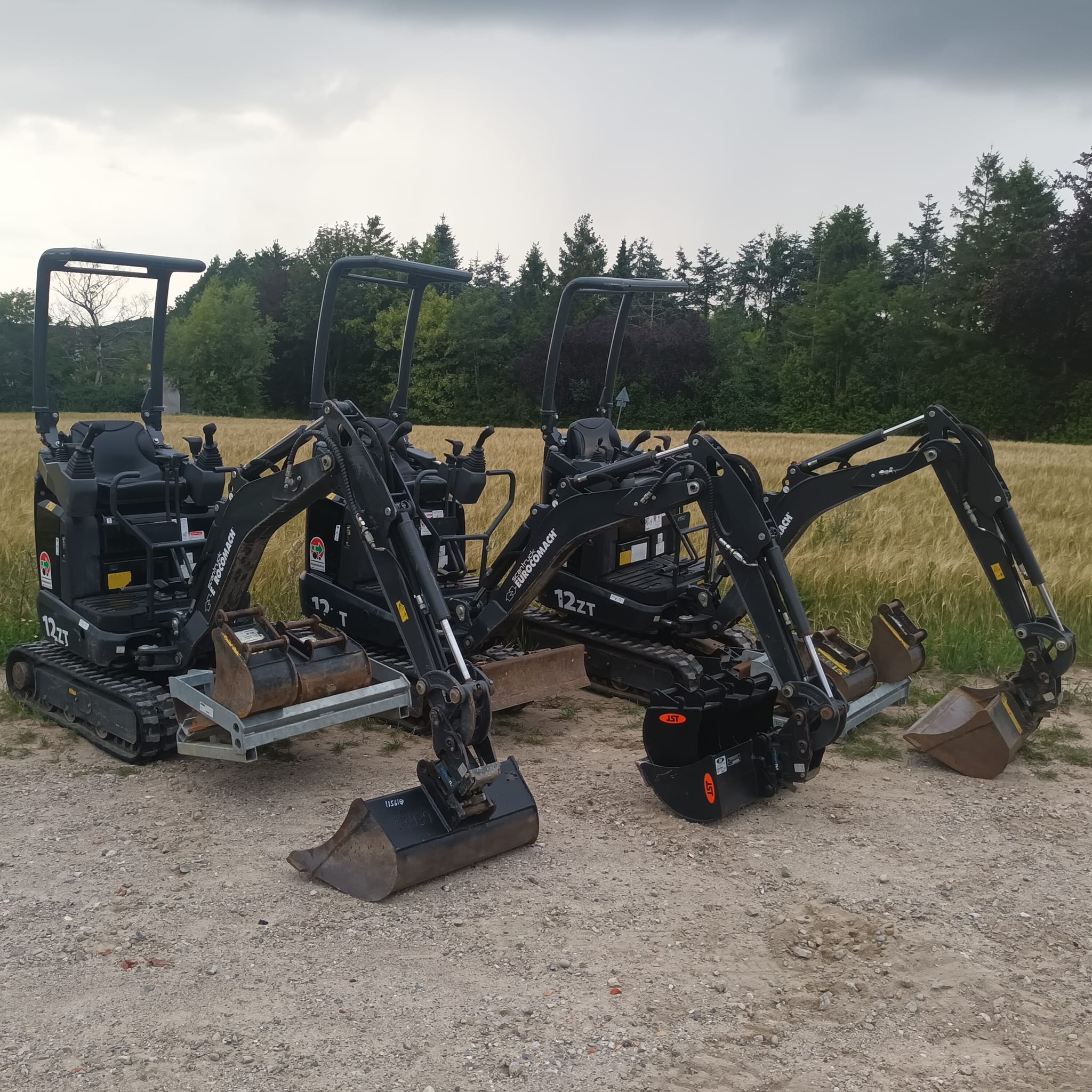 Eight shirts arranged on table in black, olive, grey, blue, white, red, mustard, and green.